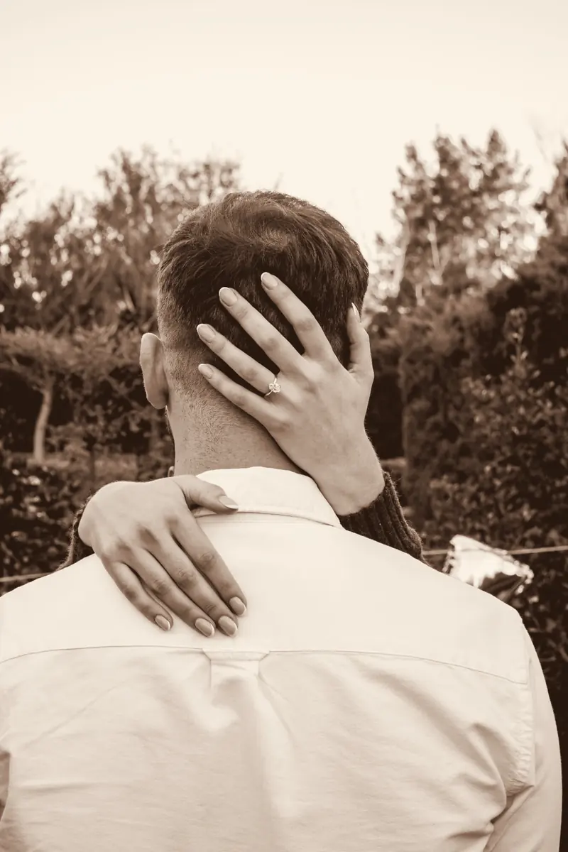 Chanel's hand with her ring resting on the back of Ivan's neck
